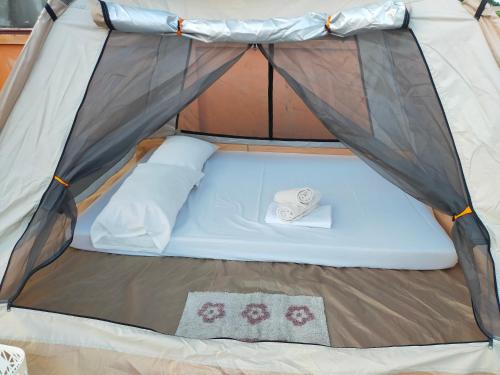 a bed in a tent with a hat in it at Touristlink Homestay in Donsol