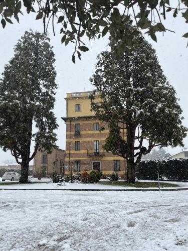 a large building with two trees in the snow at Hotel Villa Liberty in Pontecurone