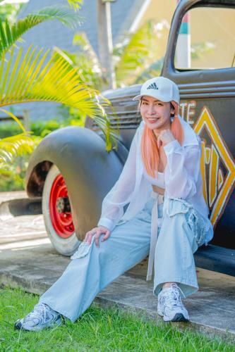 a young girl sitting on the side of a truck at Apinya Resort Bangsarey in Ban Tao Than