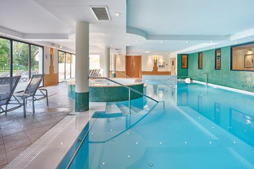 une piscine avec de l'eau bleue dans un immeuble dans l'établissement Wonderful La Villa du Lac - One Bedroom, 4 people, à Divonne-les-Bains