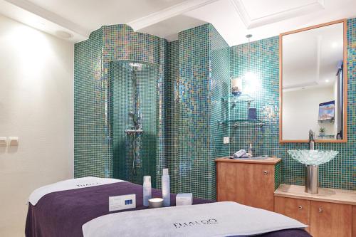 a bathroom with a shower with green tiled walls at Wonderful La Villa du Lac - One Bedroom, 4 people in Divonne-les-Bains