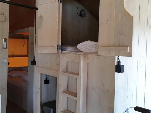 Puerta entreabierta de una habitación con cama en Safaritent Ranger Lodge, en Kesteren