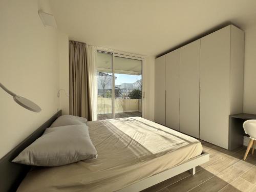 a bedroom with a bed and a large window at Sun Light in Lido di Jesolo