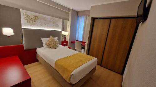 a hotel room with a bed and a sliding door at Hotel 3K Madrid in Lisbon