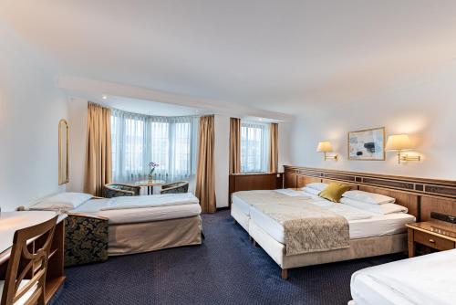 Habitación de hotel con 2 camas y mesa en Hotel Mondschein, en Innsbruck