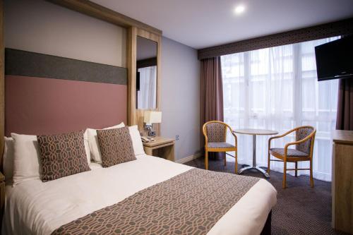 um quarto de hotel com uma cama e uma mesa em Mount Errigal Hotel, Conference & Leisure Centre em Letterkenny