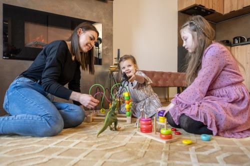 two women and a little girl playing with toys at Rezydencja Strążyska & Chalet BBQ in Zakopane