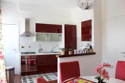 a kitchen with white walls and brown cabinets at Casanova in Alba