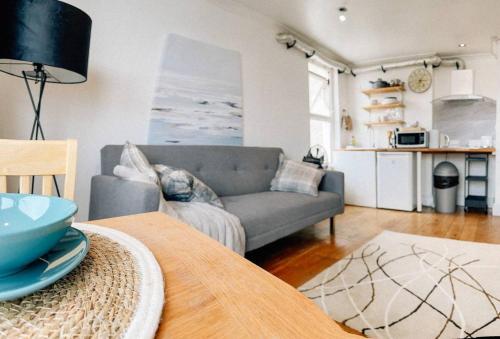 a living room with a couch and a table at Reef Lodge in Newquay