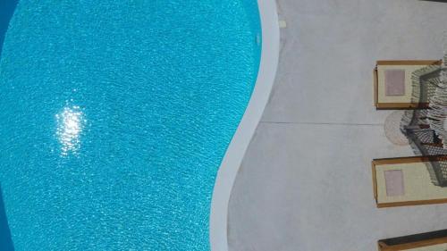 an overhead view of a swimming pool with blue water at Luxury Villa Happynest in Spasméni Vrísi