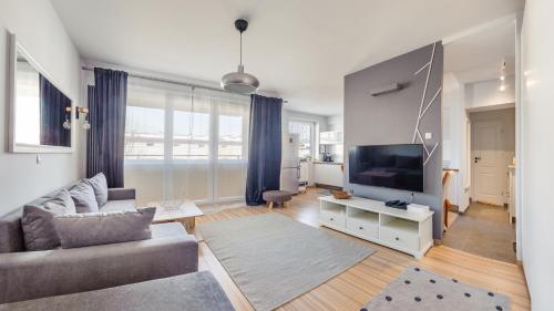 a living room with a couch and a flat screen tv at Apartamenty Sun & Snow Legionów in Gdynia