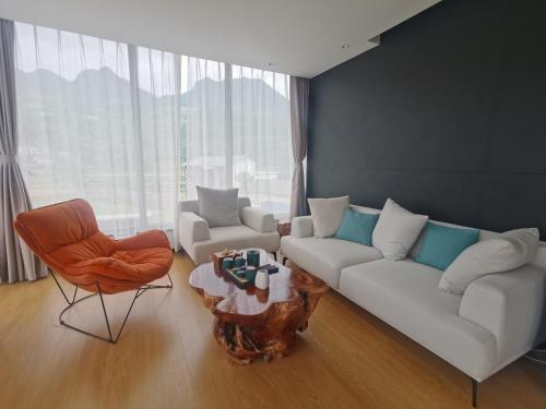 a living room with a couch and a table and chairs at XMAN Sunrise Peaks Resort--Free Pick-up in Zhangjiajie