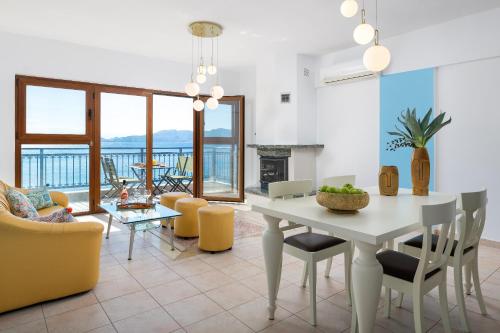 - un salon avec une table et des chaises blanches dans l'établissement Artoria Apartment 2 First Floor, à Haraki