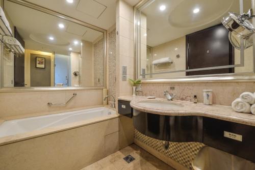 a bathroom with a tub and a large mirror at S&N Hotel Dalian in Wafangdian