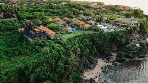 eine Luftansicht eines Resorts neben einem Fluss in der Unterkunft Uluwatu Cottages in Uluwatu