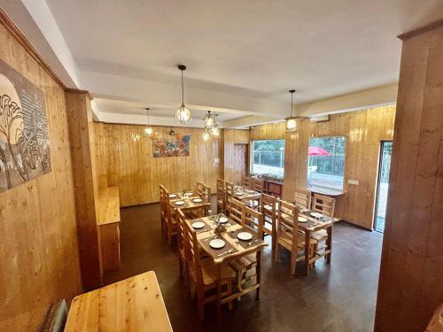a dining room with wooden tables and chairs at Amaira Resort & Farms - Mirik, West Bengal in Mirik