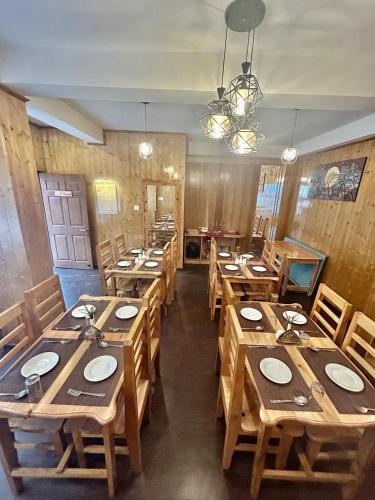 a dining room with wooden tables and chairs at Amaira Resort & Farms - Mirik, West Bengal in Mirik