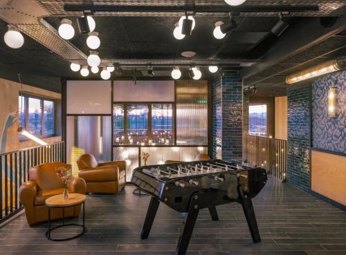 a room with a foosball table in the middle of the room at Eklo Lyon in Vénissieux