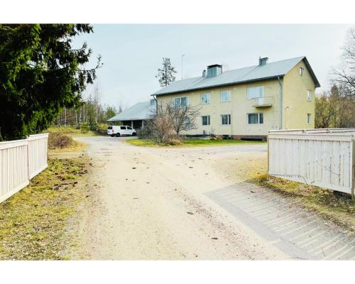 een onverharde weg voor een huis met een hek bij Easy Huoneistot Vierumäki in Härkälä