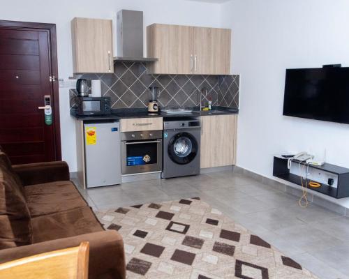 a kitchen with a stove and a dishwasher at OASIS PARK RESIDENCE in East Legon