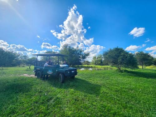 a man driving a green jeep in a field at Ditholo Game Lodge Bela Bela in Bela-Bela
