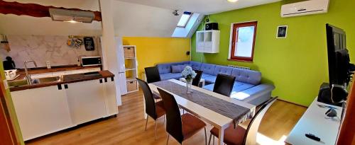 a kitchen and a living room with a table and a couch at Simonai Apartment in Bovec