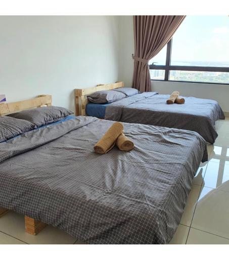 two beds with stuffed animals on them in a room at Woodsbury Suites 7722 Butterworth Penang in Butterworth