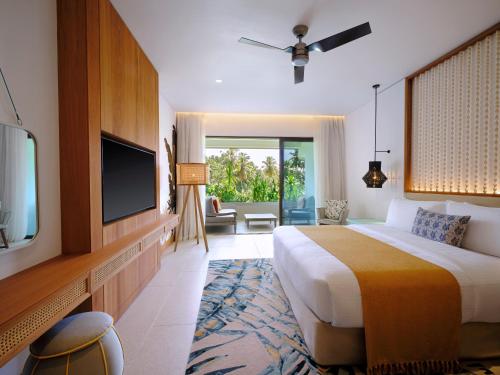 Habitación de hotel con cama, TV y sala de estar. en laïla, Seychelles, a Marriott Tribute Portfolio Resort en Mahe