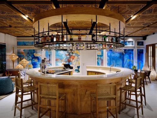 a bar in a restaurant with a large chandelier at laïla, Seychelles, a Tribute Portfolio Resort in Mahe