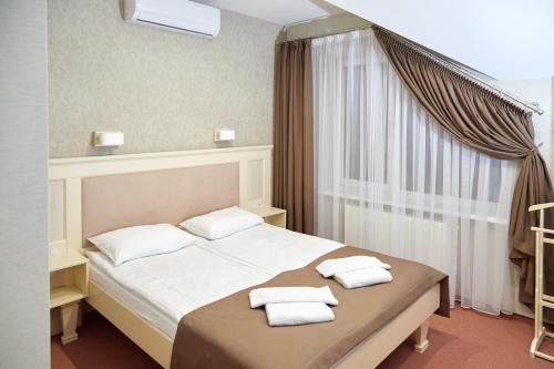 - une chambre avec un lit et 2 serviettes dans l'établissement Hotel Korona, à Mostiska