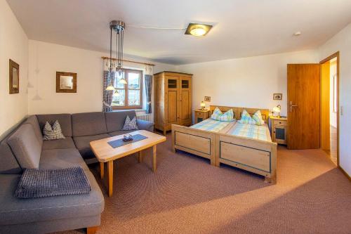 ein Wohnzimmer mit einem Sofa und einem Bett in der Unterkunft Ferienwohnung Nöß in Pfronten