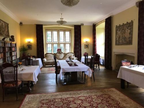 a dining room with two tables and a fireplace at Y Fan in Caerphilly