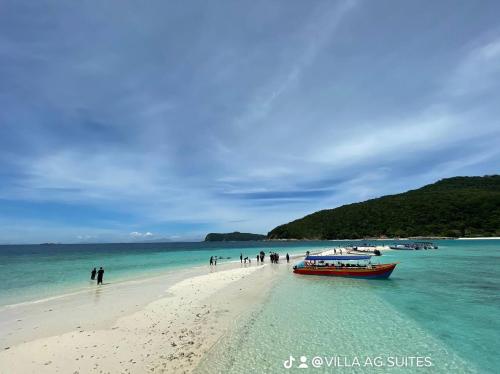 a group of people on a beach with a boat at Inap Nekmi Kuala Terengganu With Pool in Kuala Terengganu