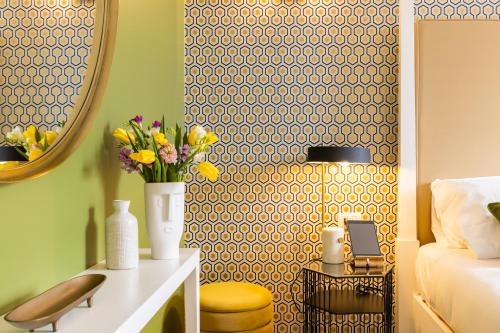 a bedroom with a bed and a mirror and flowers at Navona 49 Luxury Suites&Apartment in Rome