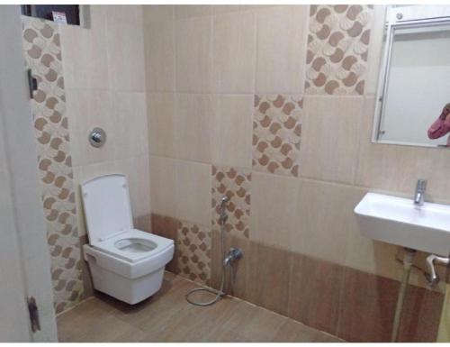 La salle de bains est pourvue de toilettes et d'un lavabo. dans l'établissement Hotel Dev Bhoomi, Uttarkashi, à Nākuri