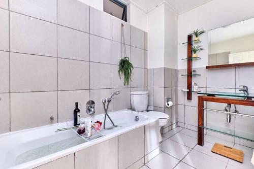 a white bathroom with a tub and a sink at Estate Lifestyle+Inverter+Wi-Fi in Roodepoort