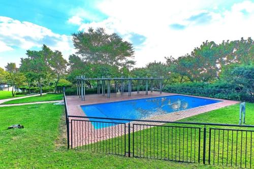 a swimming pool in a yard with a fence at Estate Lifestyle+Inverter+Wi-Fi in Roodepoort