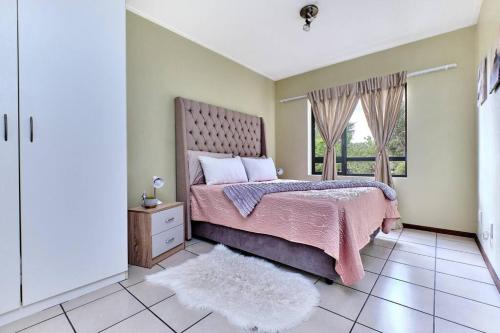 a bedroom with a bed with a pink blanket and a window at Estate Lifestyle+Inverter+Wi-Fi in Roodepoort