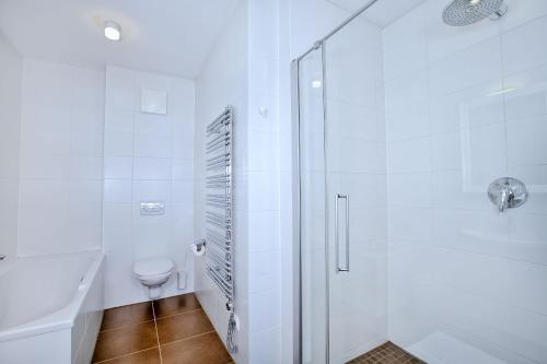 a white bathroom with a shower and a toilet at Ski In-Ski Out -Superior 2 Bedroom with Sauna at Mountain Resort Dienten am Hochkönig in Dienten am Hochkönig