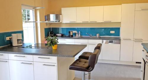 a kitchen with white cabinets and a counter top at Countryside-Lovers - Ganzes Haus 100m² für euch allein mit Garten in Halsbrücke