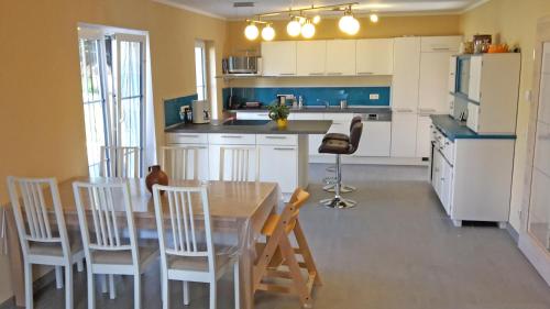 eine Küche mit einem Tisch und Stühlen in der Unterkunft Countryside-Lovers - Ganzes Haus 100m² für euch allein mit Garten in Halsbrücke