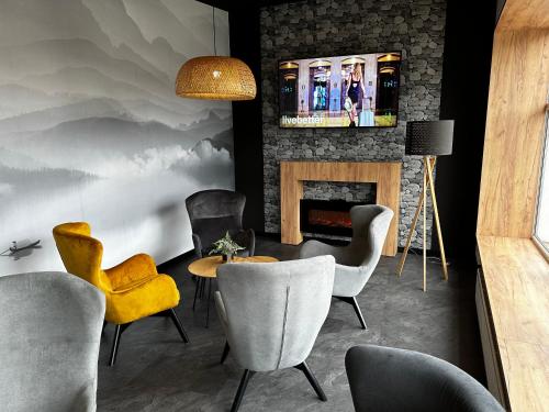 a living room with chairs and a fireplace at WRZOS resort & wellness in Węgierska Górka