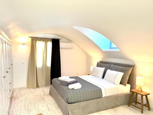a bedroom with a large bed with a large window at Oia Captain's Villa in Oia