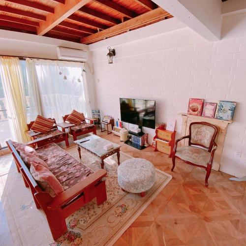a living room filled with furniture and a fireplace at 猫とピアノと星空のリゾートブティックコテージ -Starry Forest Cottage Okinawa- in Onna
