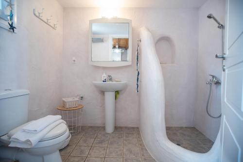 une salle de bain avec un lavabo, des toilettes et un miroir dans l'établissement Overlooking Sea Maisonette With BBQ For 7 Ppl, à Kóstos