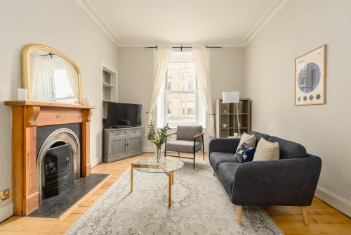 a living room with a couch and a fireplace at The Stockbridge Snug by Calton Living in Edinburgh