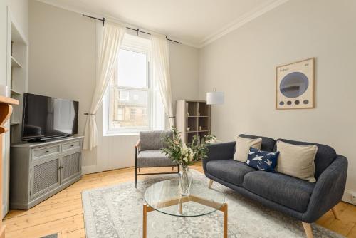 a living room with a couch and a tv at The Stockbridge Snug by Calton Living in Edinburgh