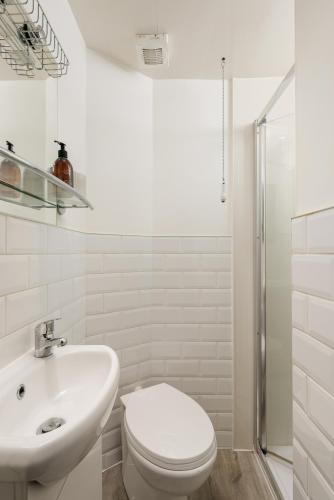 a white bathroom with a toilet and a sink at The Stockbridge Snug by Calton Living in Edinburgh