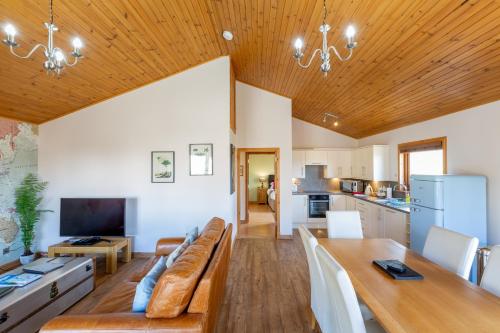 a large living room with a couch and a table at Douglas Fir Lodge with Hot tub in Cupar