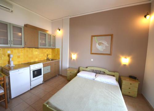 uma pequena cozinha com uma cama num quarto em Konstantza Studios and Apartments em Hermópolis